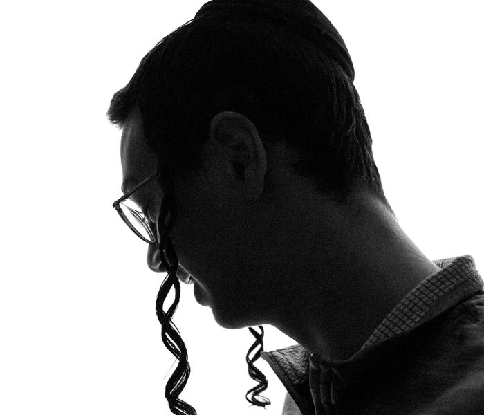 Silhouette of a man in a focused pose against a dark background with a warm glow.